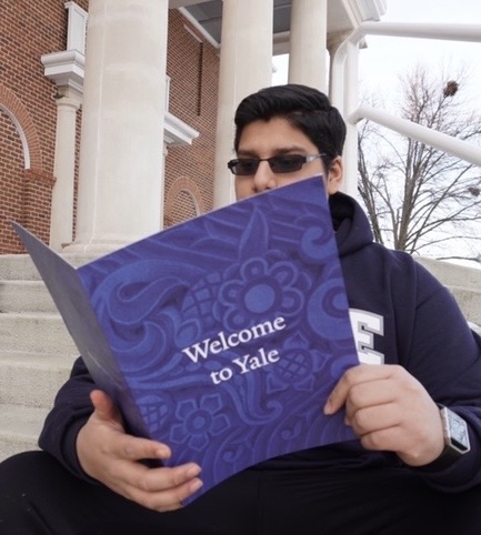 Senior Israar Ahmed reads his Yale acceptance letter while rocking a new Yale hoodie